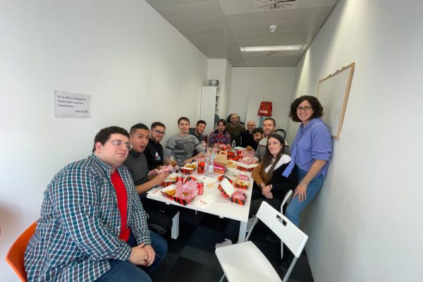 equipo-doonamis-teambuilding-comida Equipo de Doonamis sentados alrededor de una mesa comiendo hamburguesas.